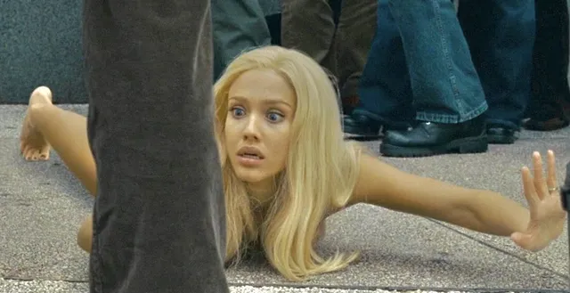 Jessica Alba lying barefoot on the floor in a screen scene.