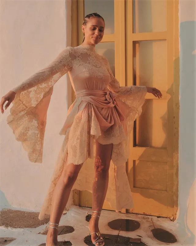 Nathalie Emmanuel standing in a doorway in an embellished pink dress.
