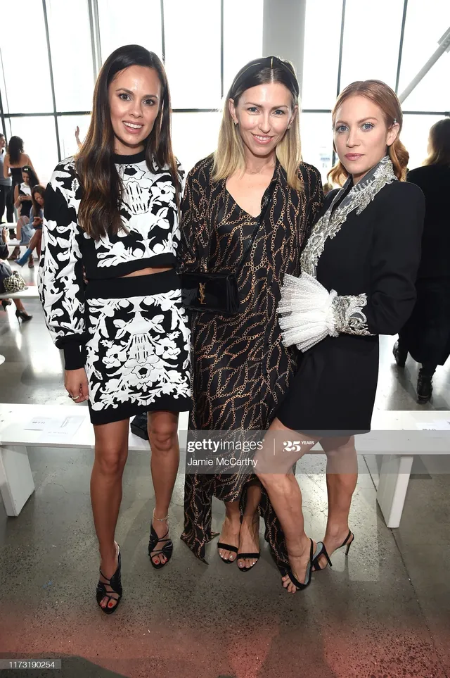 Brittany Snow posing with companions at a fashion event.