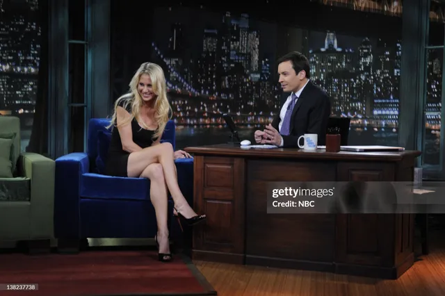 Anna Kournikova sitting in black heels during a television interview.