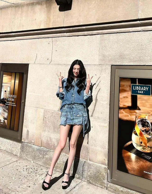 Han So-hee posing outdoors in a denim outfit and black heels.