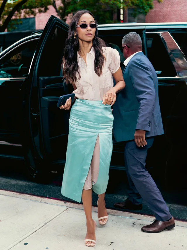 Zoe Saldaña stepping from a vehicle in a turquoise skirt.