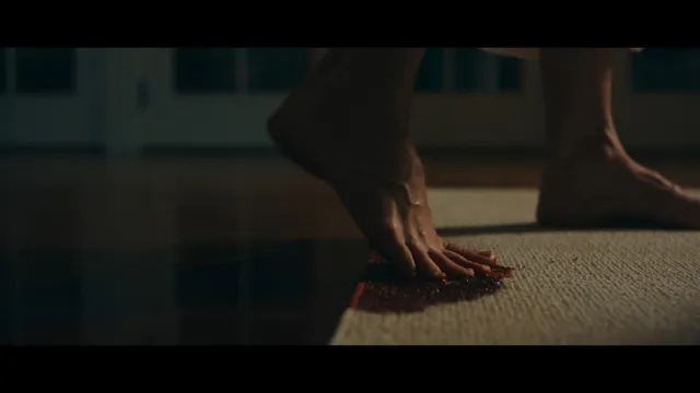 Jessica Biel a close screen detail of bare feet beside a rug.