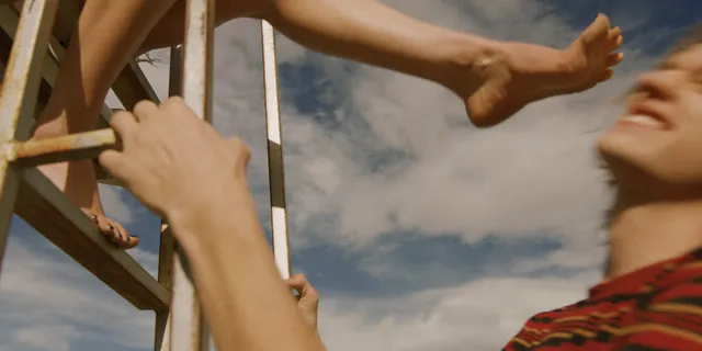 Jenna Ortega: bare foot extended from a chair in a beach scene.