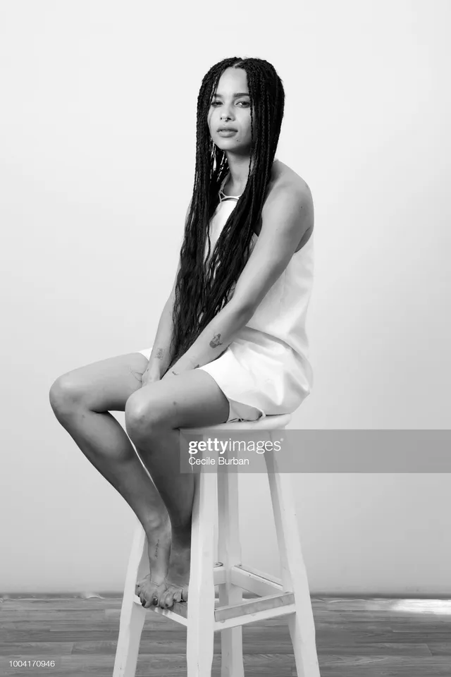 Zoë Kravitz sitting on a stool in a monochrome portrait.