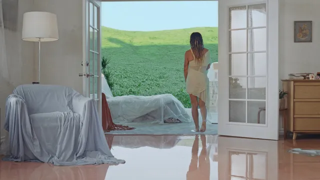 Hilary Duff standing barefoot near an open bedroom doorway.