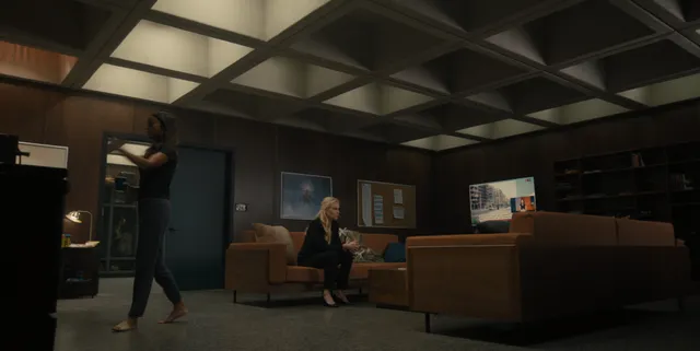 Zoe Saldaña sitting with a guest in a furnished screen scene.