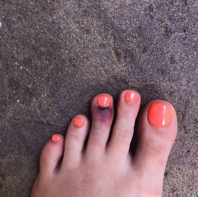 Halsey a close-up of coral-painted toenails.