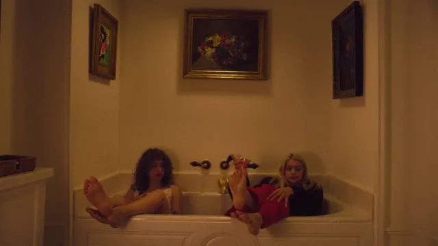 Ariel Winter sitting in a bath with a companion during a screen scene.