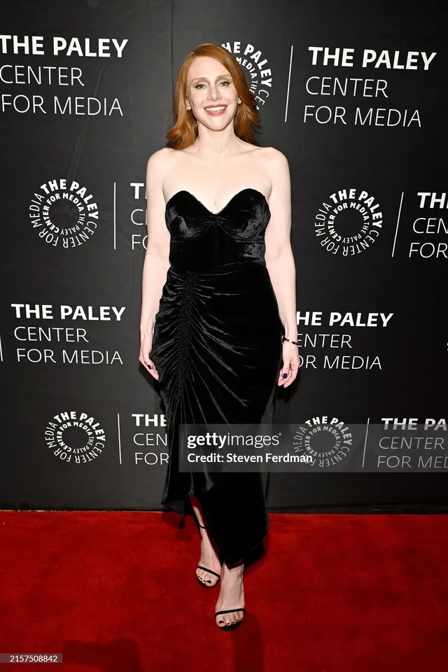 Bryce Dallas Howard posing at an event in a long black dress.