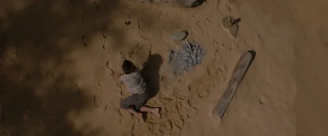 Rachel McAdams with a bare foot emerging from sand in a screen image.