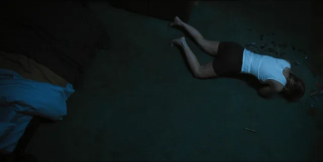 Alice Eve lying on a floor in an overhead screen scene.