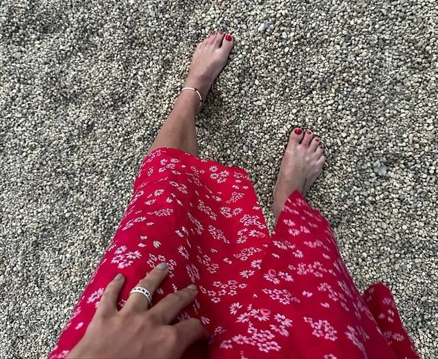 Phoebe Tonkin a casual view of bare feet with a red patterned skirt.