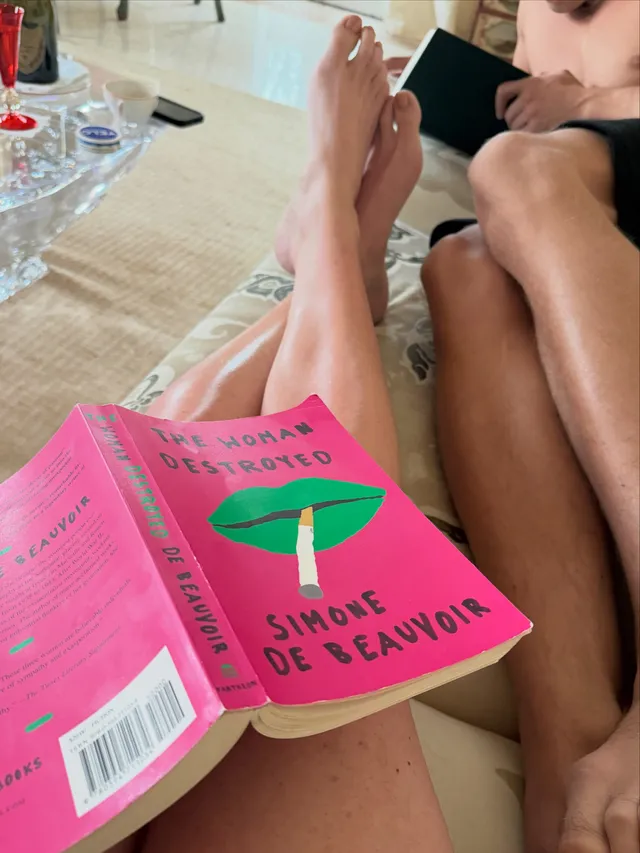Ellie Goulding resting bare legs beside a book.