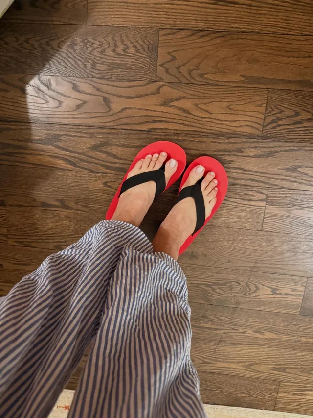 Rita Ora wearing flip-flops with striped trousers.