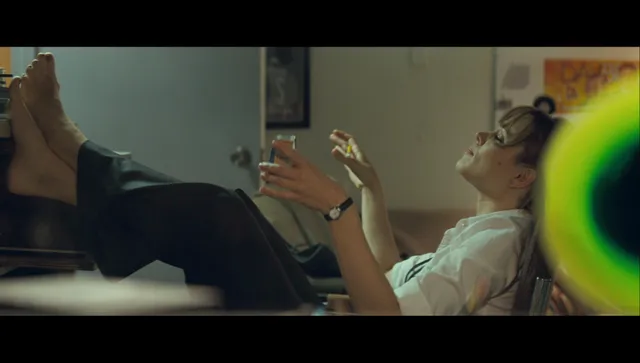 Rachel McAdams with bare feet raised indoors in a screen image.