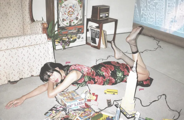 Lisa (Lalisa Manobal) lying on an indoor floor with her legs raised in patterned tights and dark heels.