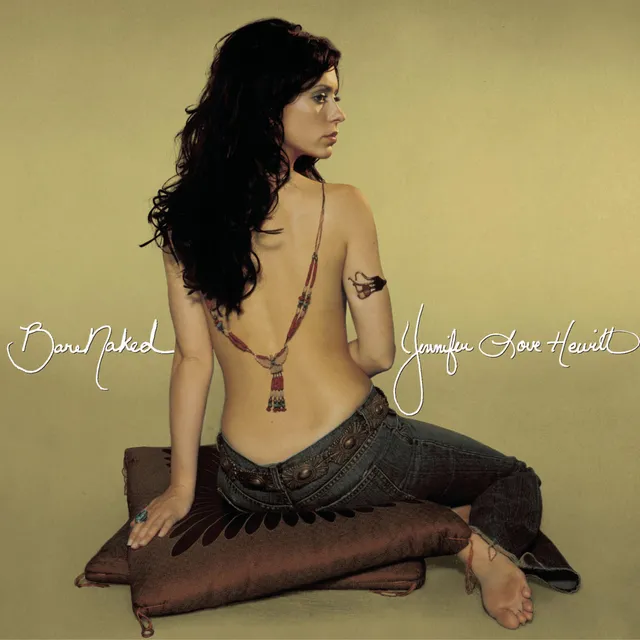 Jennifer Love Hewitt sitting on a cushion with a bare sole visible in a studio portrait.