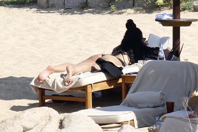 Tessa Thompson lying on her front on a beach lounger.