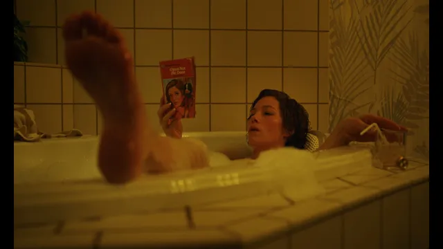 Jessica Biel a bathtub screen scene with one bare sole raised.