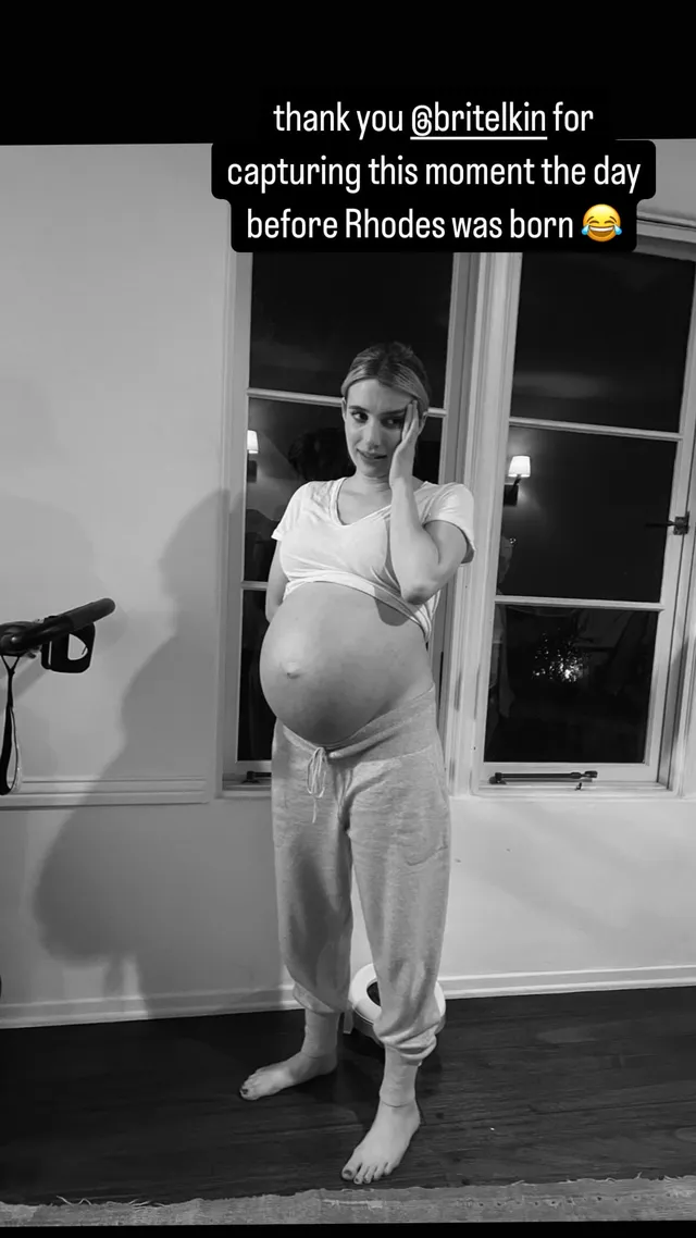 Emma Roberts standing barefoot indoors wearing a pale lounge outfit.