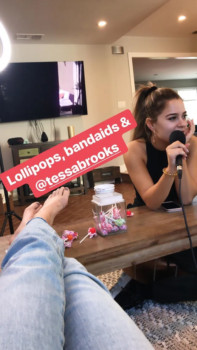 Bailee Madison resting her bare feet on a dressing table.