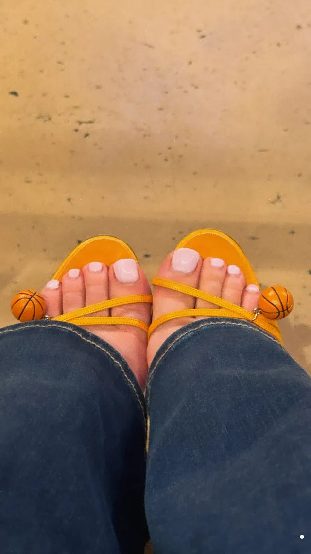 Sydney Sweeney: looking down at yellow open-toe sandals.