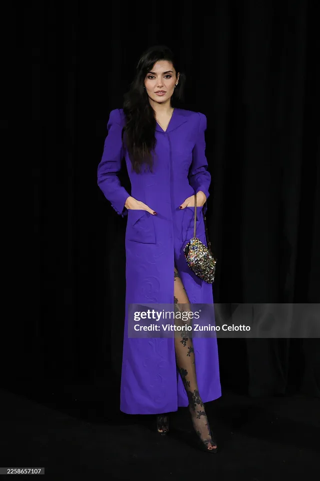 Hande Erçel wearing a purple coat dress and black heels.