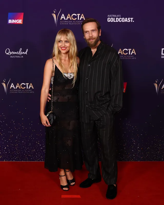 Teresa Palmer posing with a companion at an awards event.