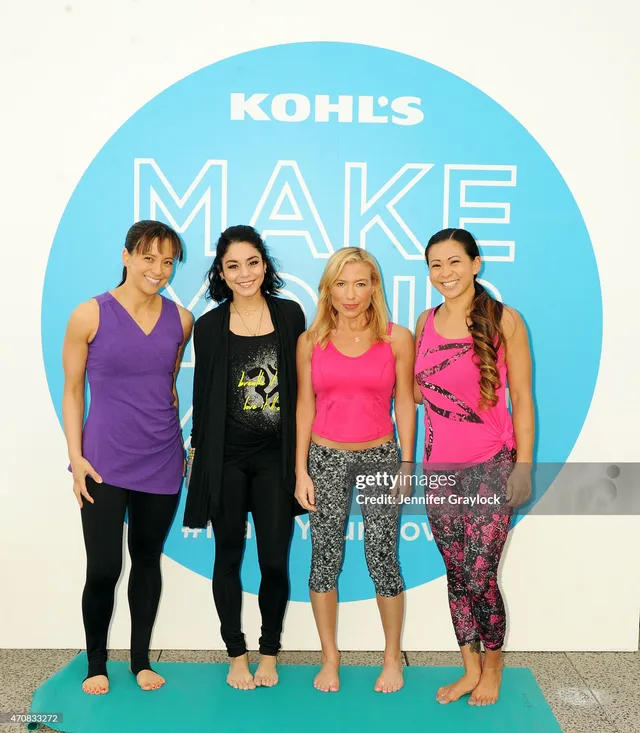 Vanessa Hudgens posing barefoot with a group on yoga mats.