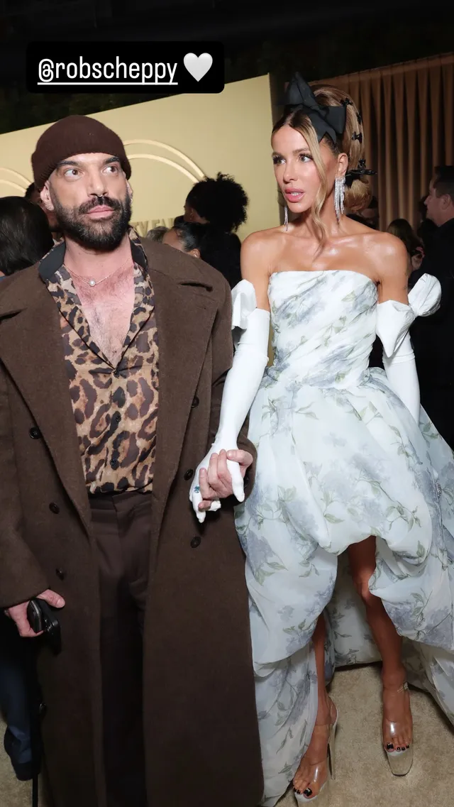Kate Beckinsale posing beside another guest in a floral dress and heels.