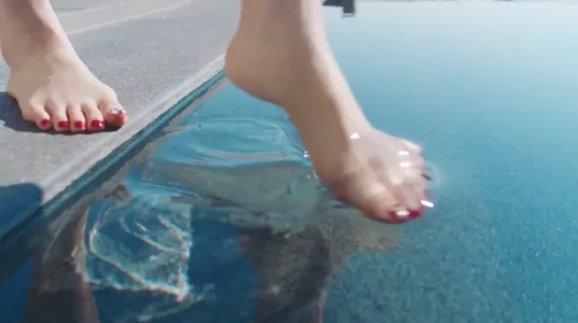 Bae Suzy dipping a bare foot into a swimming pool.
