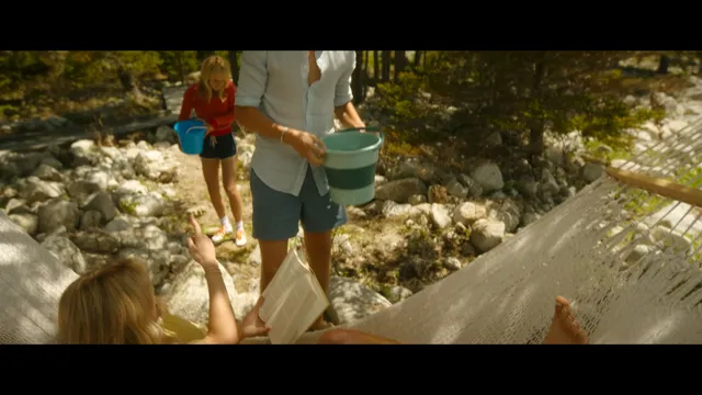 Emily Alyn Lind standing barefoot beside a hammock in a scene.