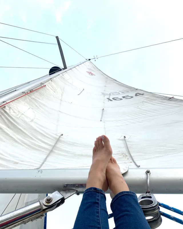 Lana Del Rey resting crossed bare feet on a sailing boat.