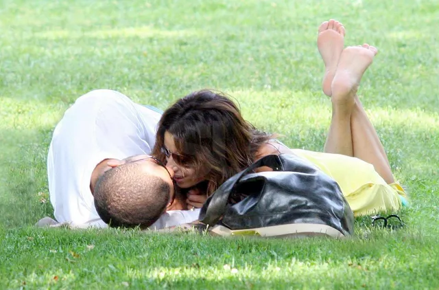 Eva Longoria lying on grass with a companion.