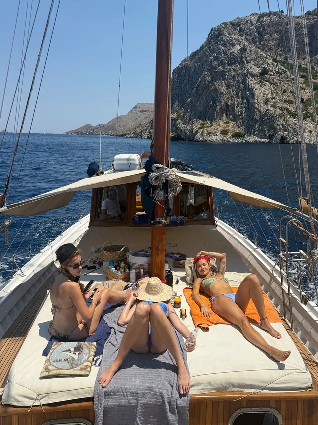 Rita Ora relaxing barefoot on a boat with other adults.