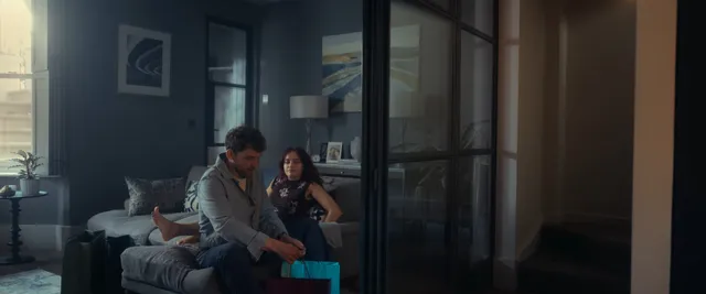 Olivia Cooke talking on a sofa in a living room scene.