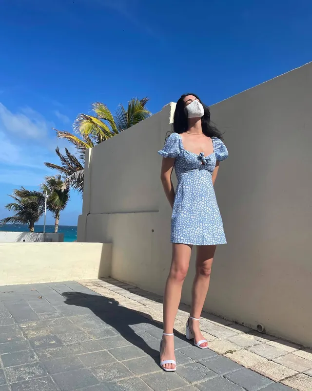 Adelaide Kane standing outdoors in a pale blue dress.
