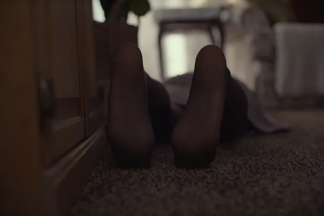 Daisy Ridley lying beside a wall in a dramatic screen scene.