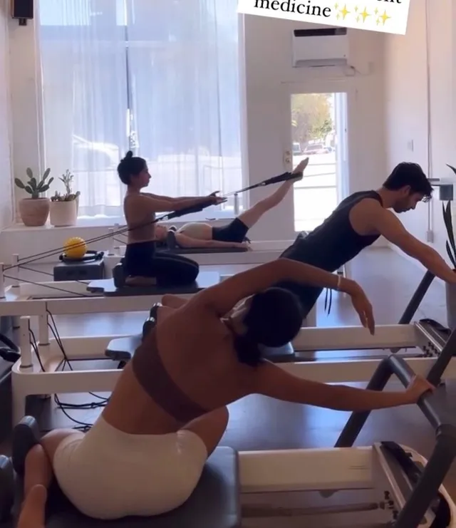 Xochitl Gomez exercising on a Pilates reformer in dark socks.