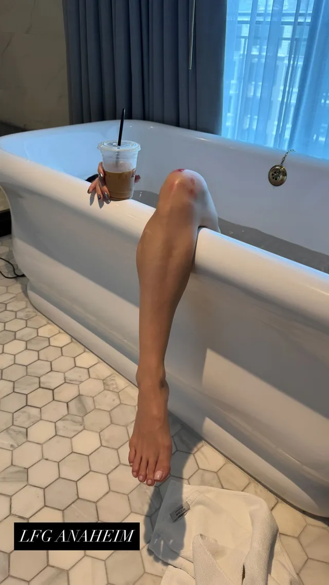 Katy Perry resting a bare leg over the side of a bathtub.
