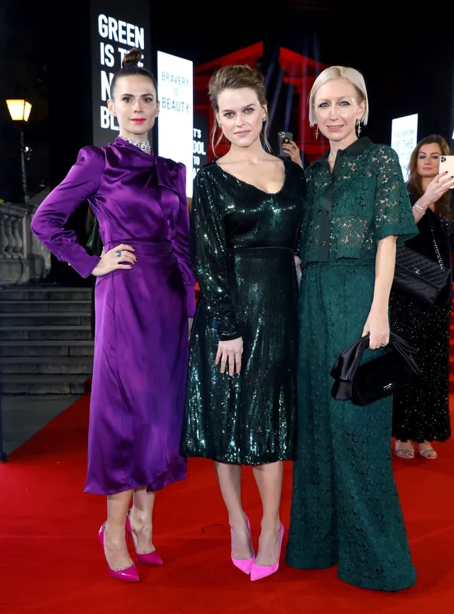 Hayley Atwell posing with other guests in a purple dress.