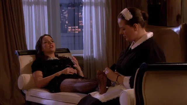Leighton Meester reclining in a chair during a screen scene.