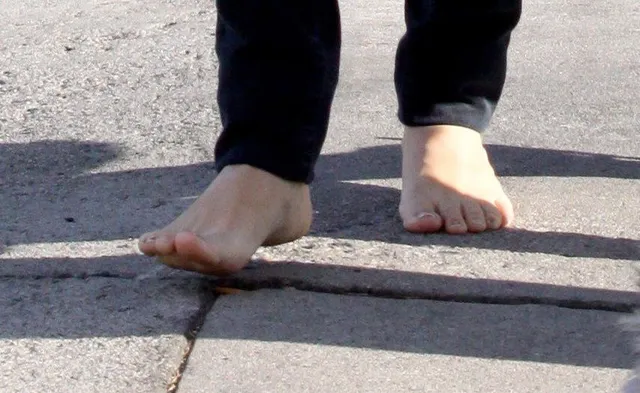 Rachel Bilson a close-up of bare feet on a pavement.