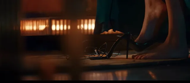 Deepika Padukone showing a dark heeled sandal during a dimly lit screen scene.