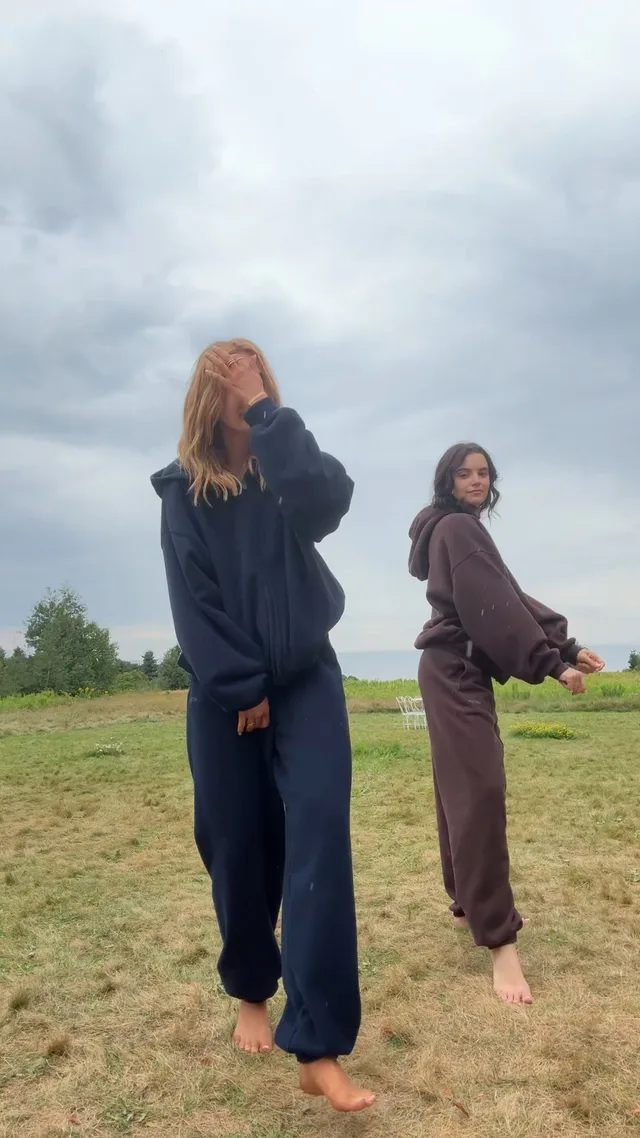Sophie Nélisse walking barefoot across a field with another woman.