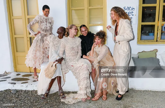 Maia Mitchell posing with guests in a floral outfit and heels.