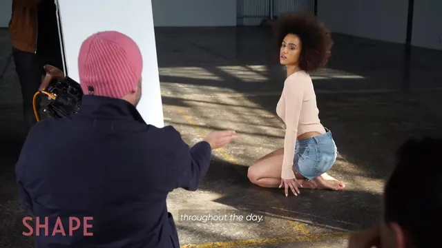 Nathalie Emmanuel sitting on a studio floor during a photoshoot.