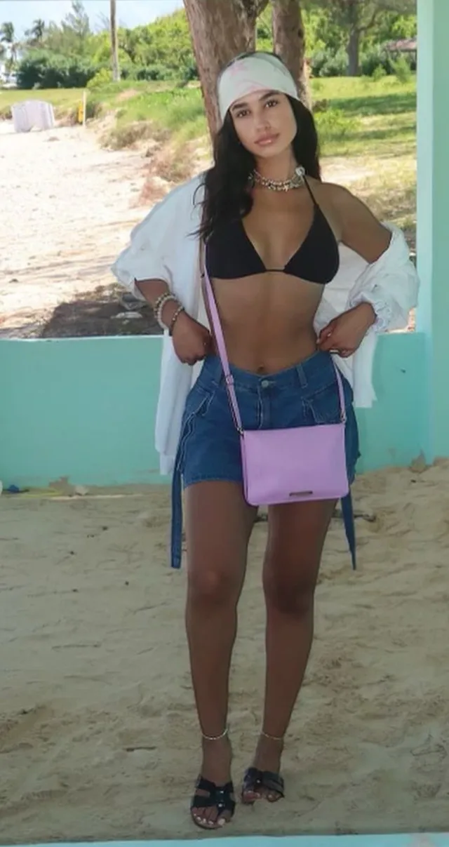 Emily Tosta standing outdoors in black sandals.