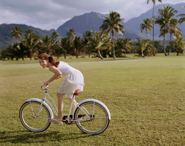 Jennifer Garner riding a bicycle on a grassy lawn.